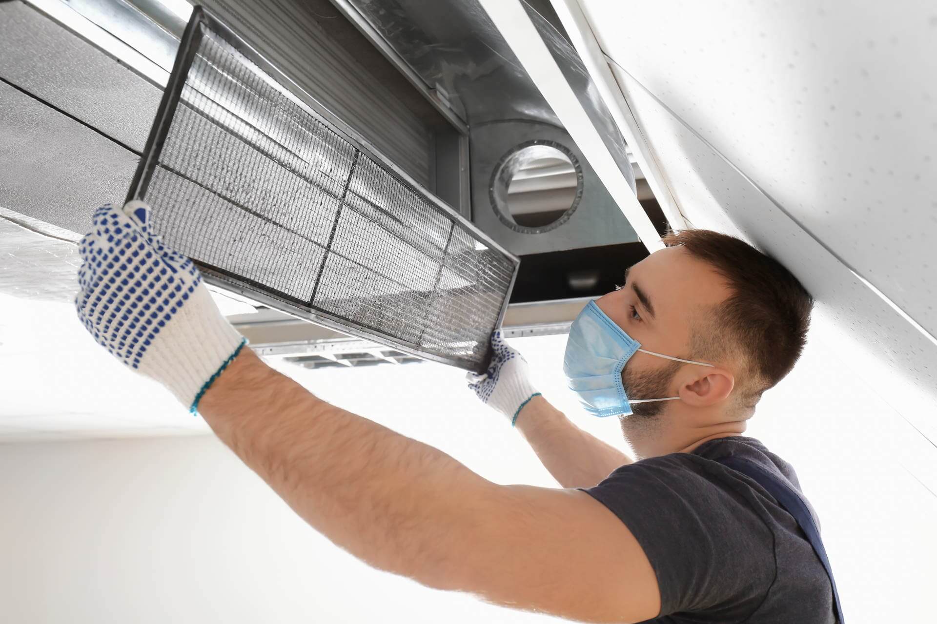 Technician cleaning residential air ducts during fall