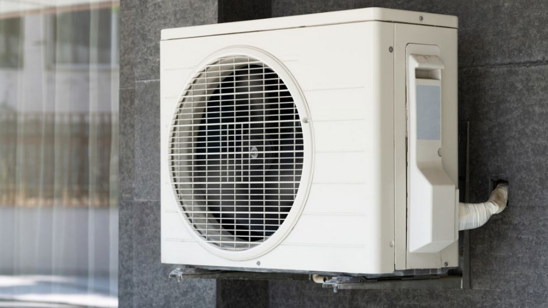 HVAC outdoor unit under cloudy sky in a suburban Southern California home